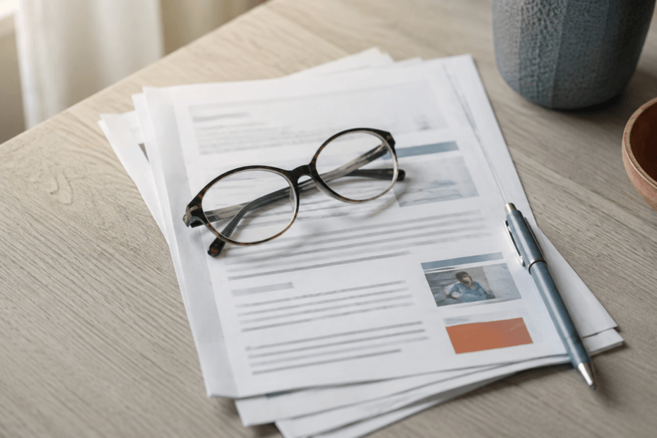 Printed surgical discharge instructions with reading glasses on a table — understanding your hip replacement precautions.